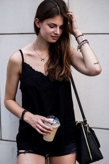 Komplett schwarzes Outfit und ein Iced Coffee