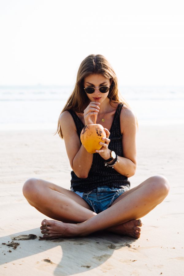 Sippint at a coconut on the beach