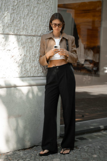 Kurze Jacke kombiniert mit Crop Top und schwarzer Hose